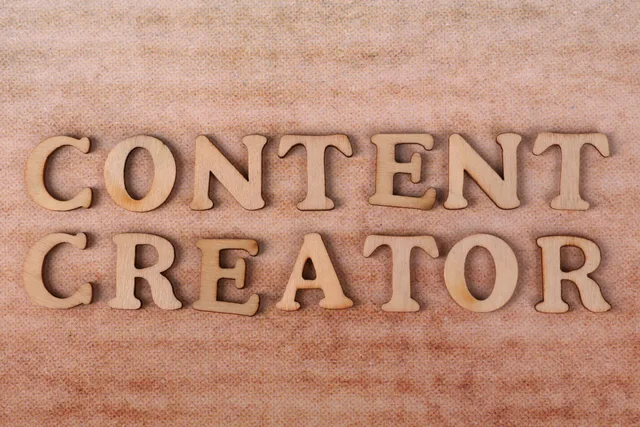 Wooden letters form 'Content Creator' on textured fabric background. Social media content planning: a practical guide