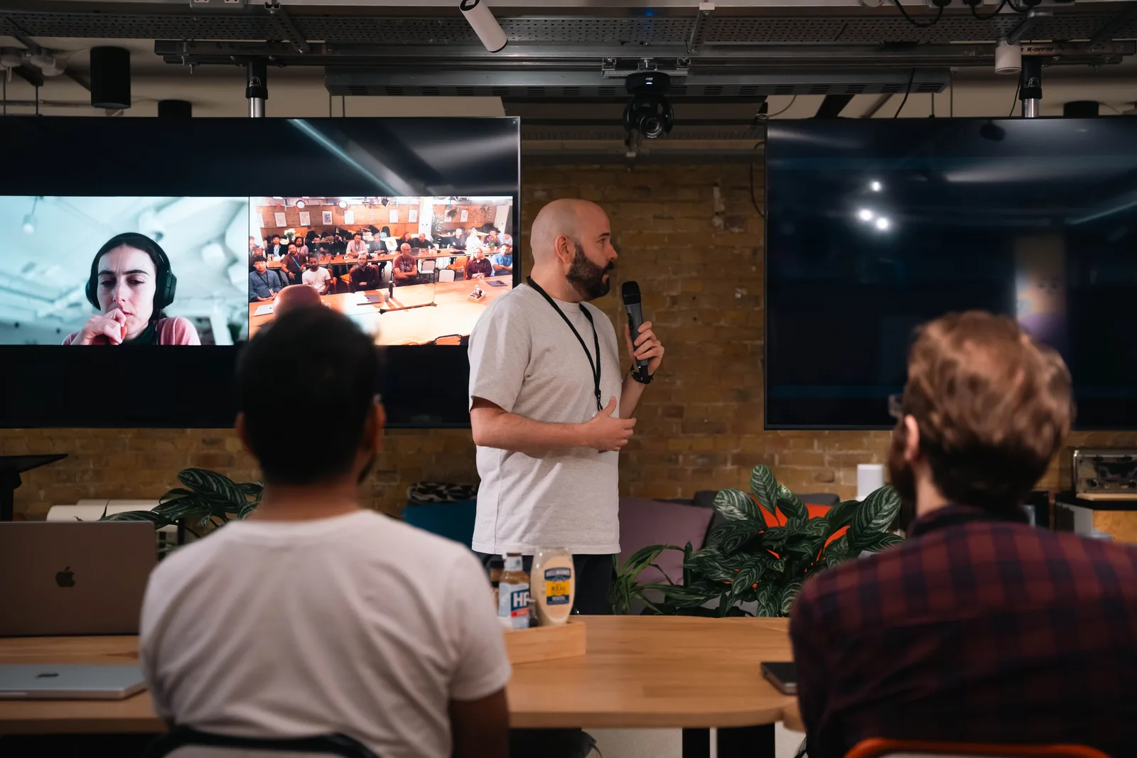 A business presentation featuring a speaker and interactive video call in an office setting. Social media strategy explained for business teams