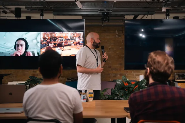 A business presentation featuring a speaker and interactive video call in an office setting. Social media strategy explained for business teams